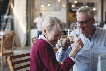 Loving senior man and woman enjoying champagne in restaurant - MASF01755
