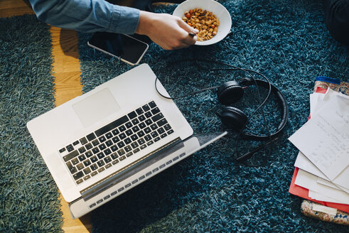 Hohe Winkel Ansicht der Geschäftsmann sitzt mit Snack und Laptop auf dem Teppich im Büro Cafeteria - MASF01763