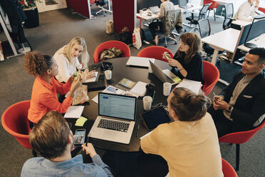 Blick aus einem hohen Winkel auf multiethnische Mitarbeiter, die am Konferenztisch im Büro eine Strategie diskutieren - MASF01764