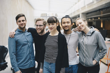 Gruppenbild von selbstbewussten männlichen und weiblichen Computerprogrammierern, die zusammen in einem Büro stehen - MASF01778