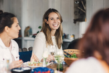 Happy young female friends enjoying at dining table during lunch party - MASF01808