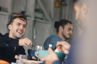 Glückliche junge männliche Freunde sitzen am Esstisch - MASF01809