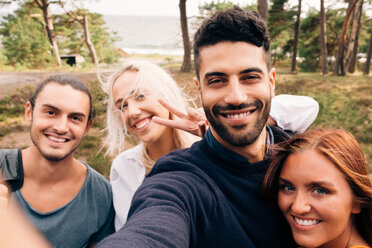 Glückliche männliche und weibliche Freunde nehmen Selfie im Wald - MASF01818