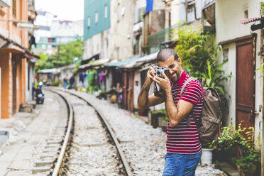 Vietnam, Hanoi, Mann in der Stadt, der ein Foto mit einer altmodischen Kamera macht - WPEF00211