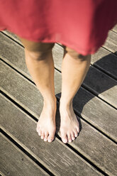 Feet of woman standing on deck - JOSF02165