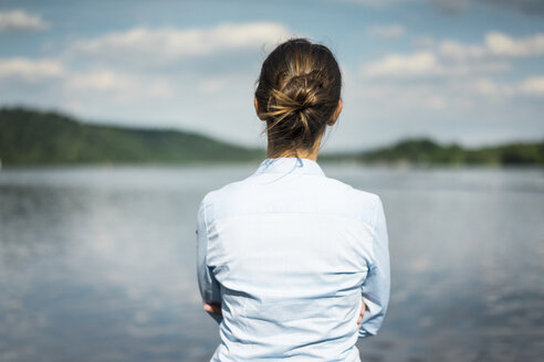 Rückansicht einer Frau an einem See mit Blick auf die Aussicht - JOSF02167