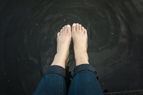 Füße einer Frau im Wasser eines Sees - JOSF02181