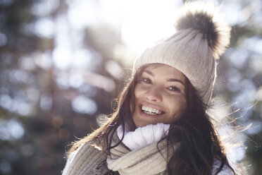 Portrait of happy young woman in winter forest - ABIF00288