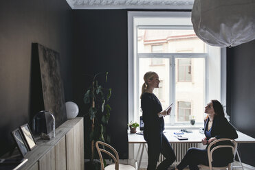 Weibliche Mitarbeiter diskutieren am Schreibtisch im Home Office - MASF01919