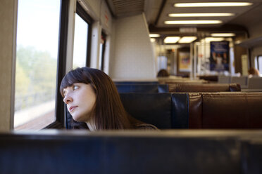 Woman looking away while traveling in train - CAVF35477