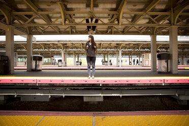 Frau wartet auf dem Bahnhof auf einen Zug - CAVF35479