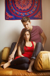Porträt eines lesbischen Paares, das zu Hause auf dem Sofa sitzt - CAVF35509