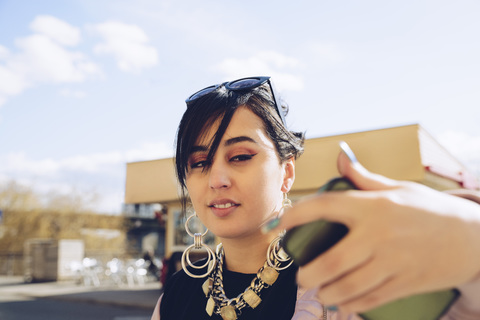 Junge Frau macht Selfie mit Smartphone in der Stadt, lizenzfreies Stockfoto