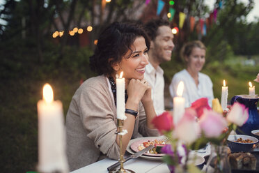 Smiling friends sitting at decorated table in garden party - MASF02012