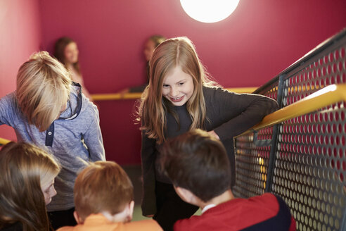 Lächelndes Mädchen mit Freunden auf der Treppe einer Mittelschule - MASF02043