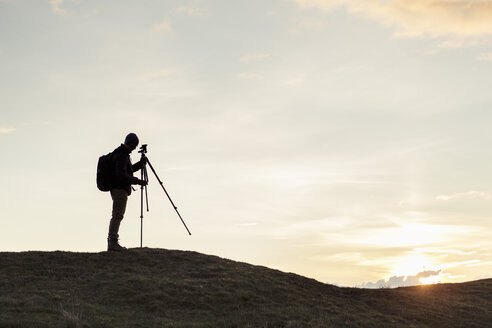 Seitenansicht der Silhouette Wanderer Befestigung Stativ auf dem Hügel gegen den Himmel bei Sonnenuntergang - MASF02065