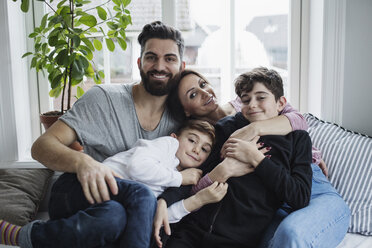 Porträt einer glücklichen Familie auf dem Sofa im Wohnzimmer zu Hause - MASF02127