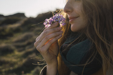 Woman enjoying fragrance of a flower - KKAF00938