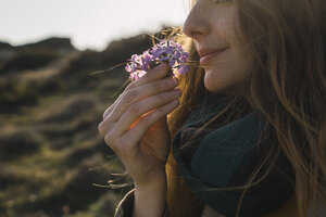 Frau genießt den Duft einer Blume - KKAF00938