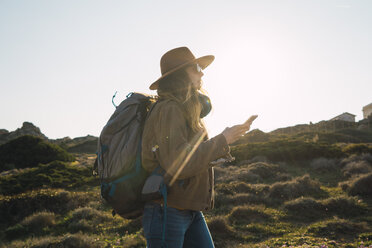 Italien, Sardinien, Frau auf Wanderschaft mit Handy in der Hand - KKAF00941