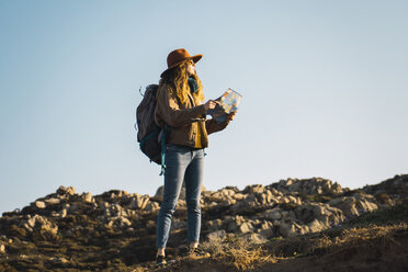 Italien, Sardinien, Frau mit Landkarte auf einer Wandertour - KKAF00945