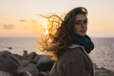 Italien, Sardinien, Porträt einer Frau an der Küste bei Sonnenuntergang - KKAF00969