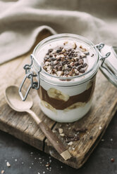 Kokosnussjoghurt und Schokoladen-Chiasamen-Dessert mit Banane, gekrönt mit Kakaonibs und Haselnüssen - IPF00440