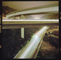 Lights trails on overpass by mountain during sunset - CAVF35661