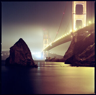 Niedriger Blickwinkel auf die beleuchtete Golden Gate Bridge über der Bucht bei nebligem Wetter - CAVF35662