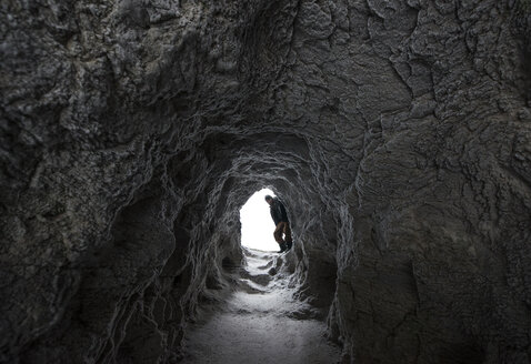 Wanderer steht am Eingang einer Höhle am Icefields Parkway - CAVF35756