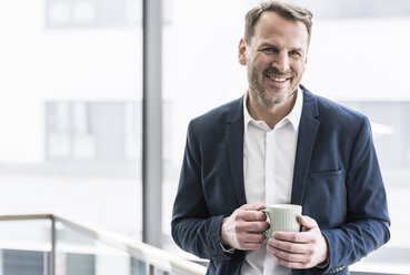 Porträt eines lächelnden Geschäftsmannes in einer Kaffeepause - UUF13276