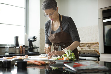 Frau zerkleinert Fleisch bei der Zubereitung von Speisen zu Hause - CAVF35786
