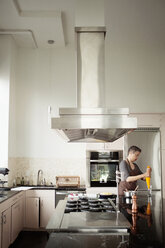 Frau hält Zuckergussbeutel, während sie in der Küche steht - CAVF35798
