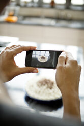 Frau fotografiert selbstgebackene Torte mit Smartphone - CAVF35802