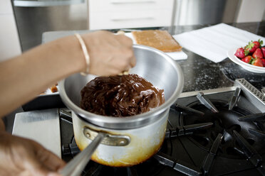 Beschnittenes Bild Frau gibt Lebensmittel in geschmolzene Schokolade - CAVF35811