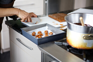 Frau schneidet Essen für Dessert in Küche zu Hause - CAVF35812