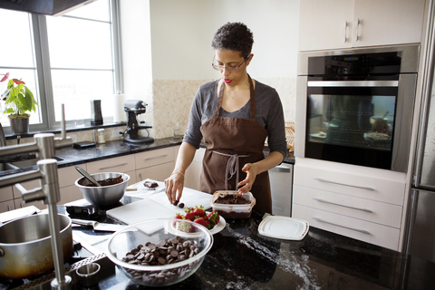 Frau macht Schokoladentrüffel zu Hause, lizenzfreies Stockfoto