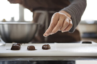 Mittelteil einer Frau, die Puderzucker auf ein hausgemachtes Dessert streut - CAVF35822