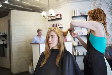 Seitenansicht einer Friseurin, die einer Frau im Salon die Haare schneidet - CAVF35914