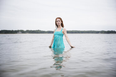 Portrait of woman standing in sea against sky - CAVF36007