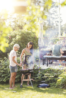 Reife Frauen kochen Essen im Grill im Hinterhof während Gartenparty - MASF02241