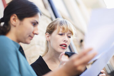 Mid adult Geschäftsfrauen diskutieren über Dokumente außerhalb des Büros - MASF02276