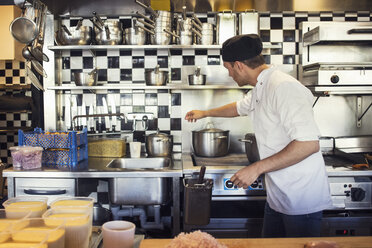 Männlicher Koch beim Kochen in der Küche eines Restaurants - MASF02324