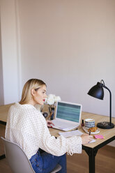 Blonde Geschäftsfrau sitzt am Schreibtisch und arbeitet - EBSF02357