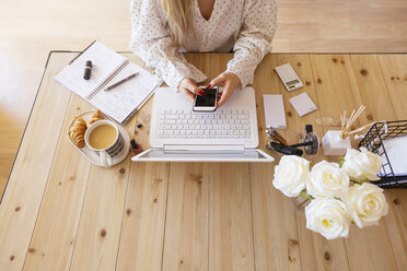 Young woman sitting at desk, using laptop - EBSF02373