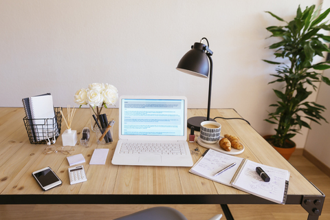 Laptop on desk in a bright and friendly office stock photo