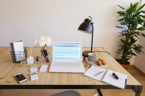 Laptop auf dem Schreibtisch in einem hellen und freundlichen Büro - EBSF02374