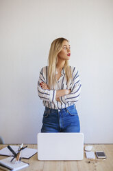 Young busnesswoman standing in office with arms crossed, looking away - EBSF02383