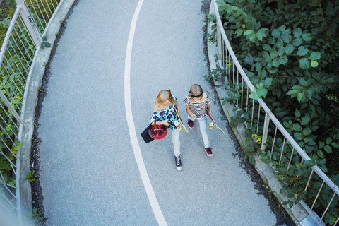 Hohe Winkel Ansicht von Mädchen zu Fuß auf Brücke inmitten von Bäumen, lizenzfreies Stockfoto