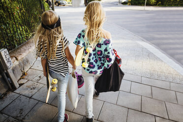 Hohe Winkelansicht von Freunden, die Skateboards tragen, während sie auf dem Bürgersteig gehen - MASF02385